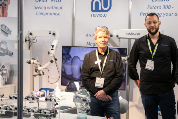 two sales men stand at an exhibition booth at the Dentistry Show