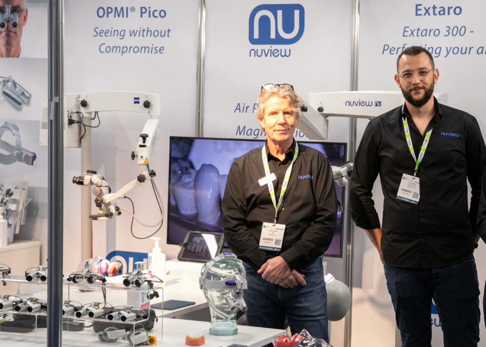 two sales men stand at an exhibition booth at the Dentistry Show